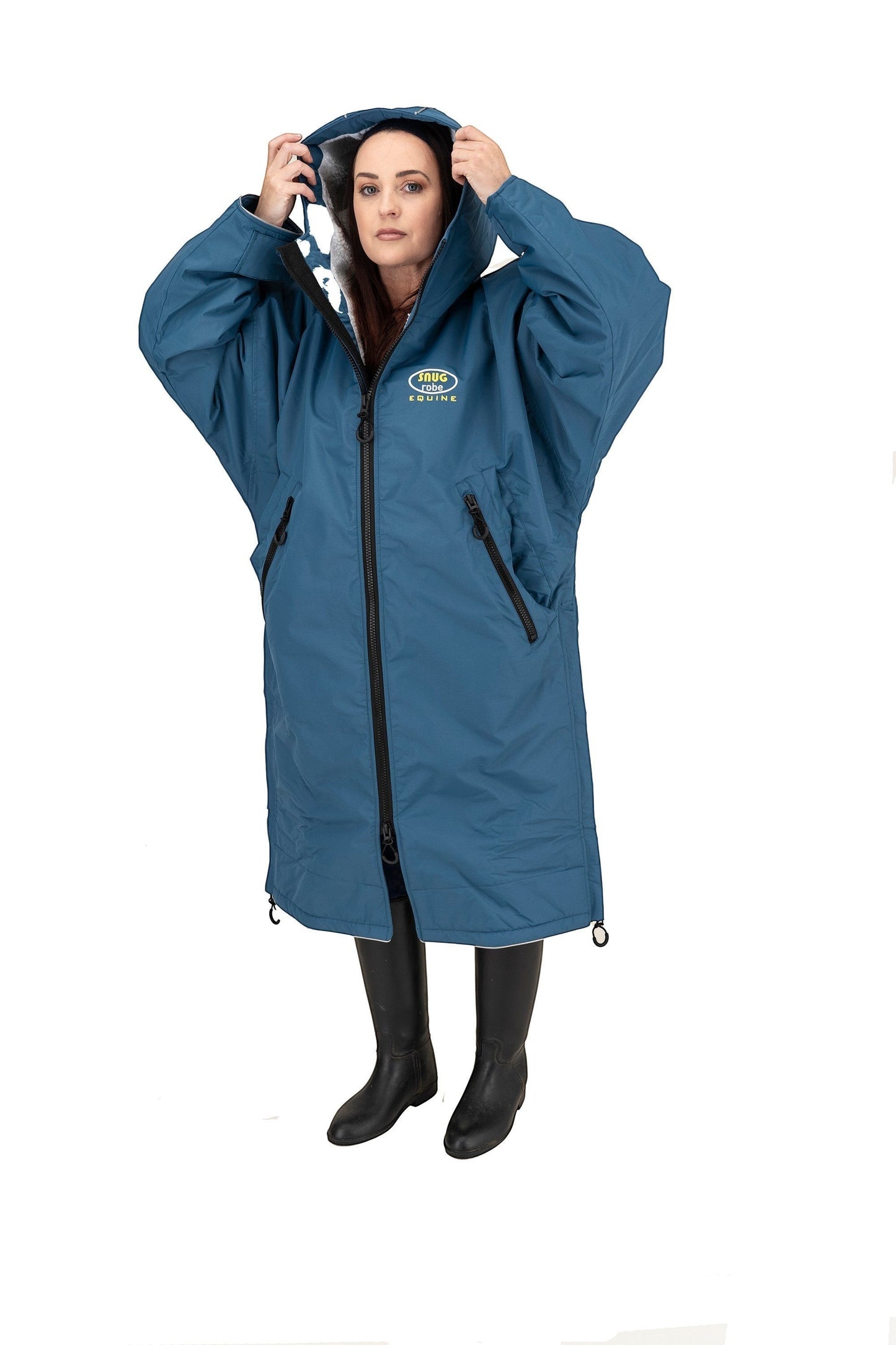 Snugrobes Equine waterproof blue robe with fleece lining, hood, and adjustable cuffs. Model wears black boots.